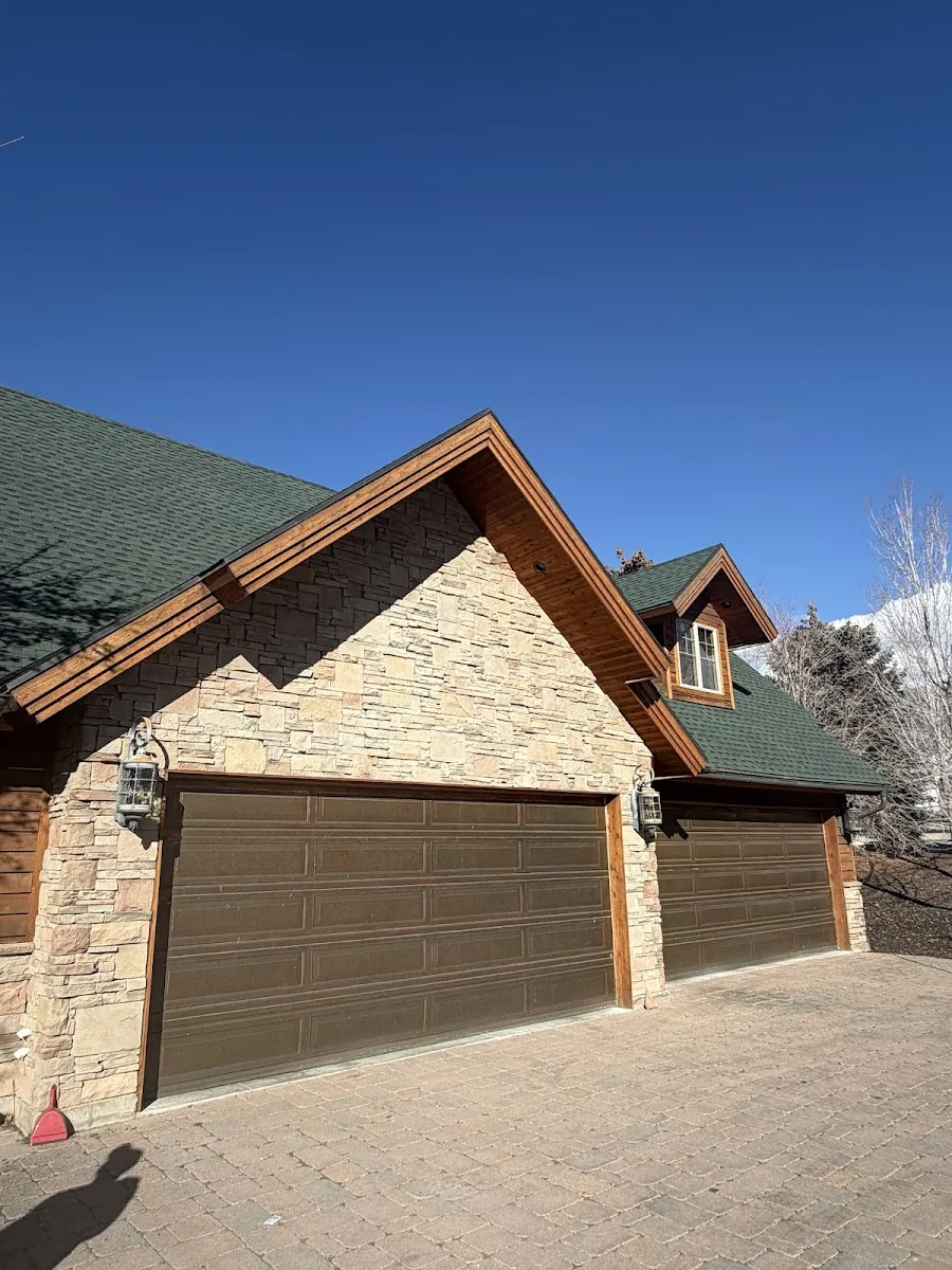 Stone and wood Utah home with completed green shingle roof by Frame Roofing Utah