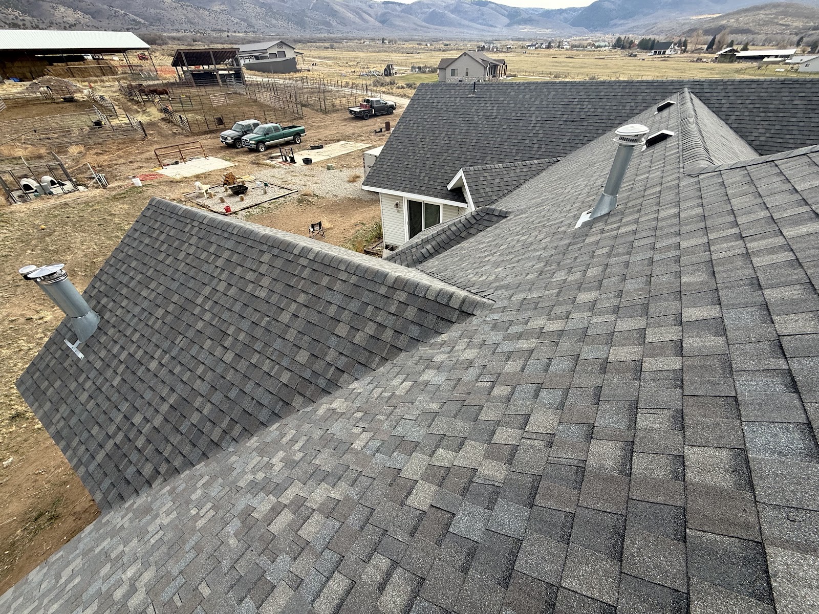 Completed gray shingle roof installation in Utah with mountain views