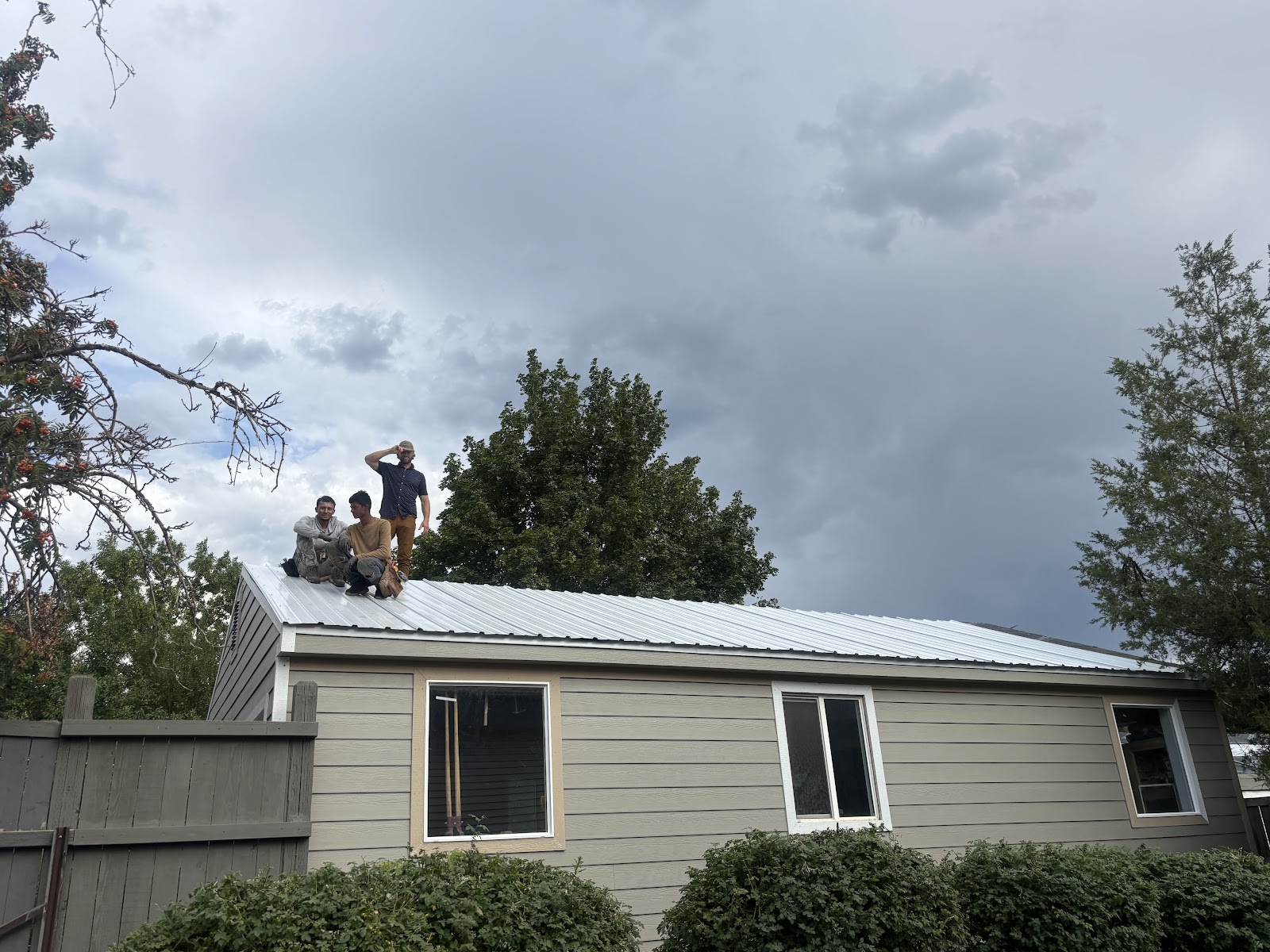 Crew installing metal roof panels on Utah home