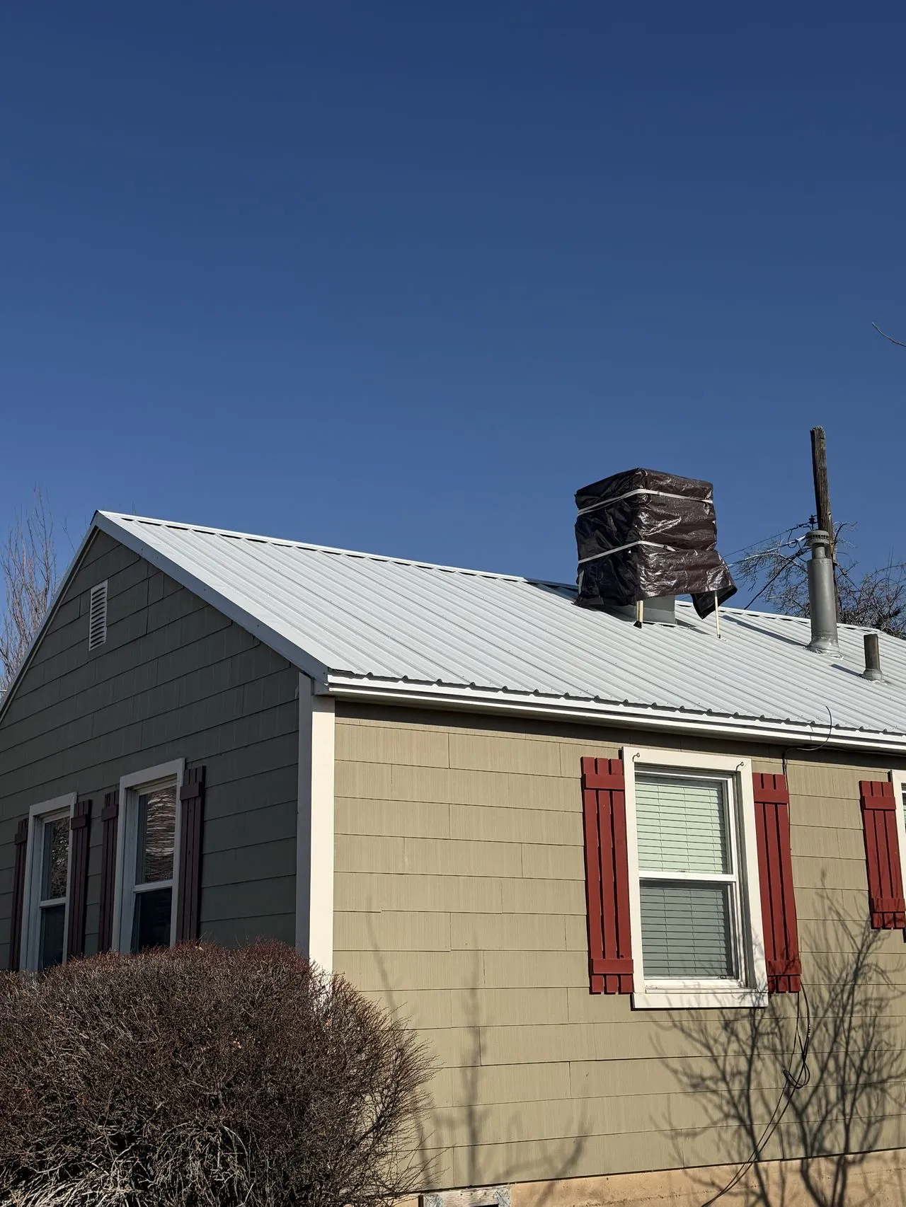 Frame Roofing Utah technician performing a spring rooftop inspection on a Utah residence - looking for winter damage and sealant failures